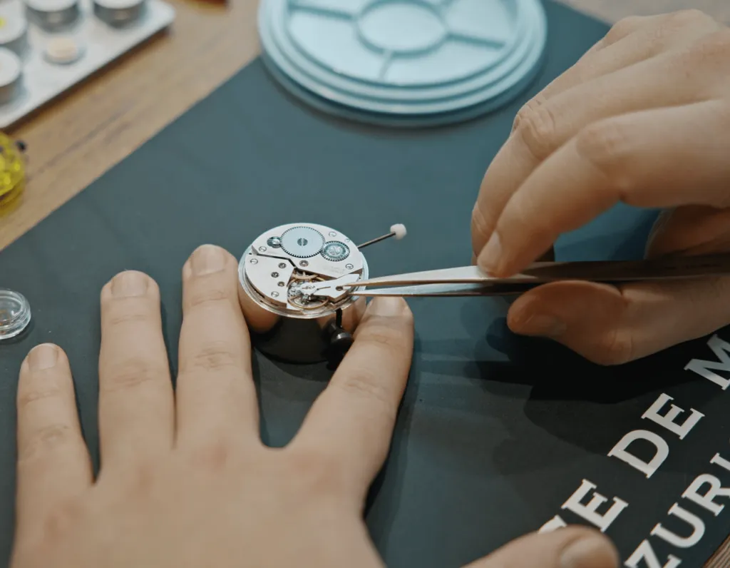 Close-up of hands assembling a mechanical watch movement with tweezers at Maurice de Mauriac in Zurich — Byca watchmaking experience.