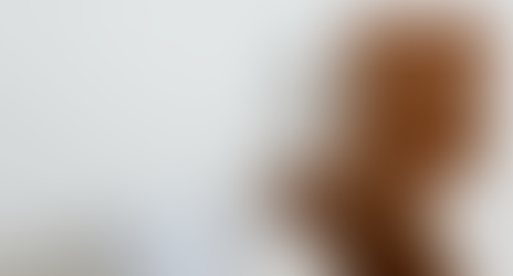 Minimalist product shot of a sculptural wooden Z-chair with six circular backrest cutouts, paired with a white glossy round floor lamp. Captured at Kiosk.io’s design studio in Zurich.