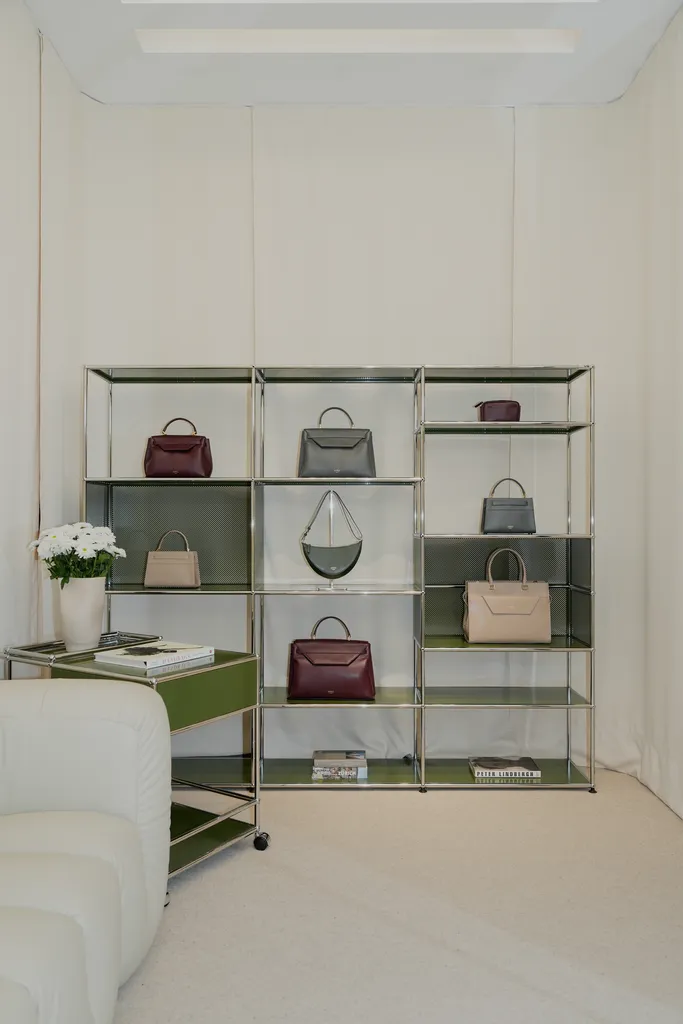 Display shelves showcasing AMELI Zurich handbags in a stylish pop-up store with neutral tones and a clean aesthetic.