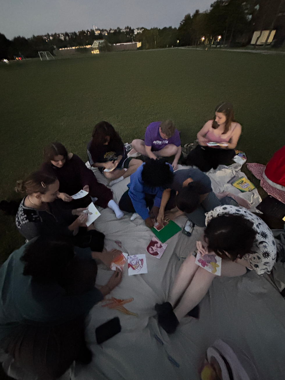 A group of freshman dorm residents creating their artwork while enjoying the great lawn (Photo by Raina Roller)