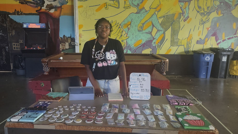 Kami Forde with a table filled with self made art (Photo by Tia Porter) 
