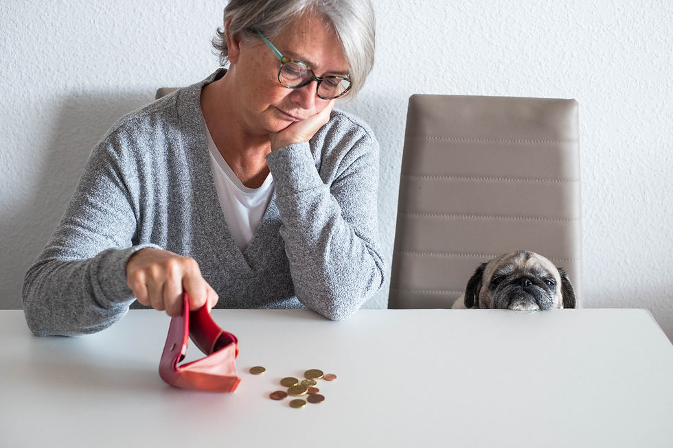 Oudere vrouw met lege portemonnee en munten op tafel met een mopshond droevig ernaast