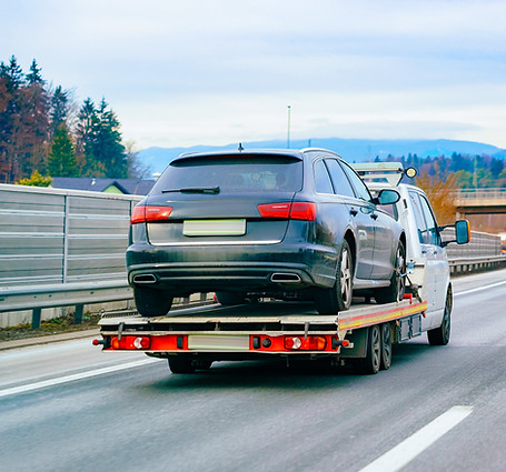 Audi met pech word opgehaald door een witte takel wagen en is onderweg op de snelweg