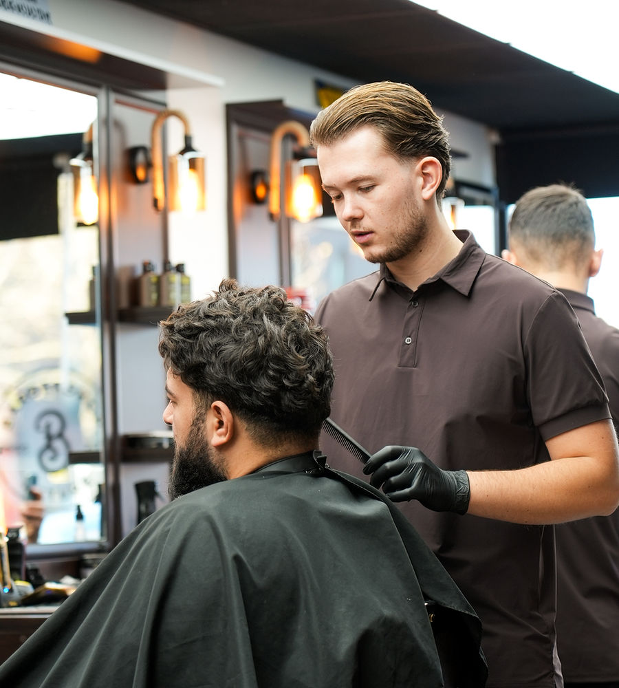 Barbier van Barbershop Future aan het werk in de shop in Stein