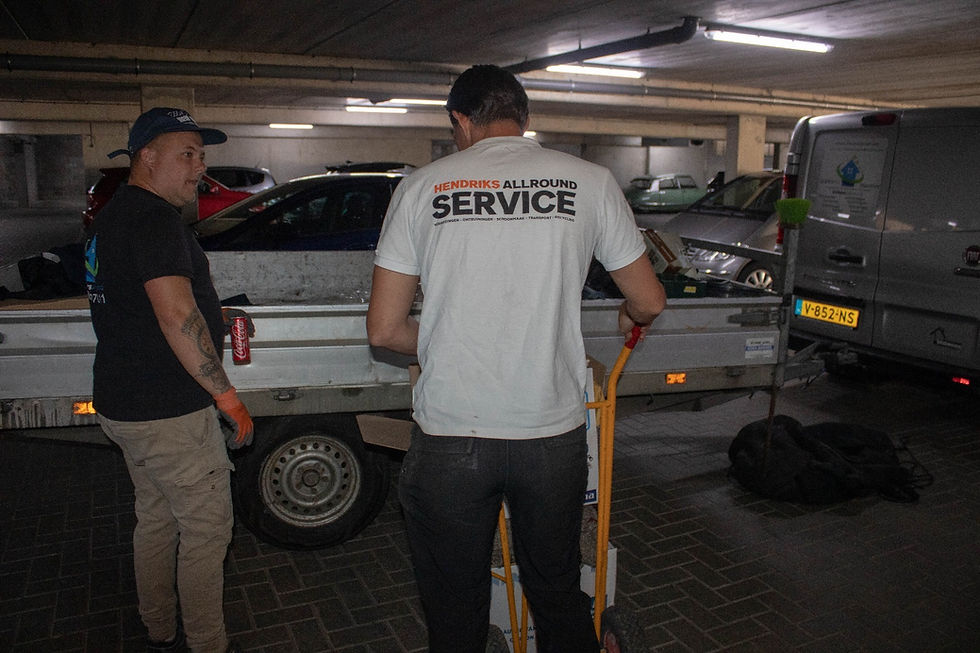 2 mannen die bij een aanhangwagen staan