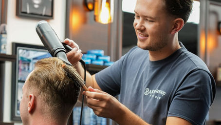 Barbier FÖHNT een man in de barbershop