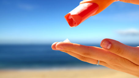 zonnebrand creme op vrouwen hand