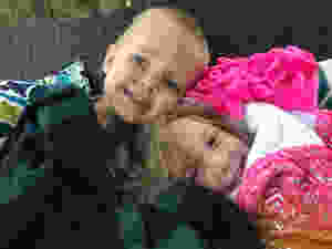 bundled up kids sitting on the swing