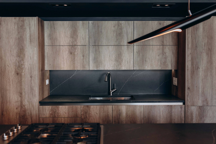 a kitchen with a black countertop and two chairs