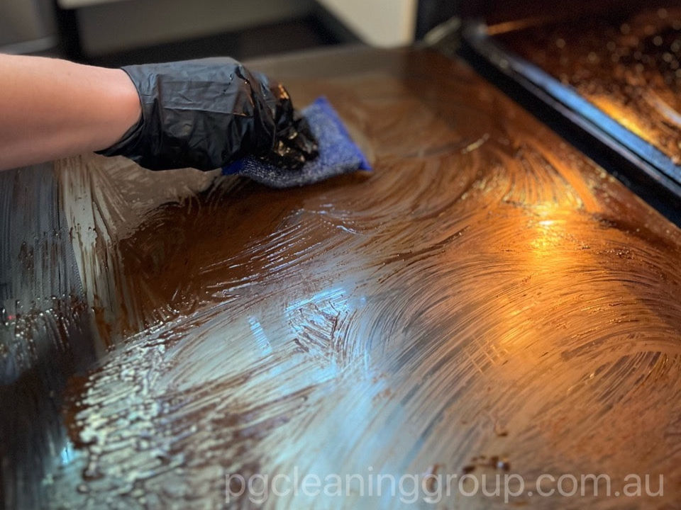 Applying professional degreaser during end of lease oven cleaning in Melbourne before a final inspection.