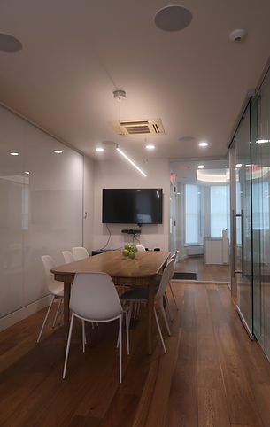 Conference room with wood flooring and mounted TV in a NW Washington DC office renovation.