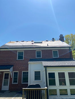During roof replacement in Chevy Chase Washington DC showing new roof underlayment and partially installed shingles from ground view