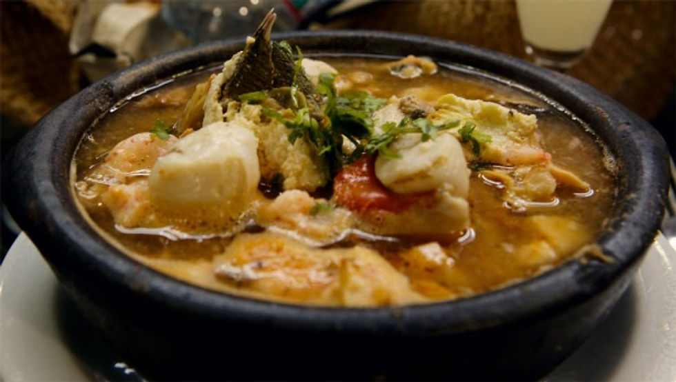 Curanto - a fish, shellfish, sausage and potato stew garnished with a giant barnacle.