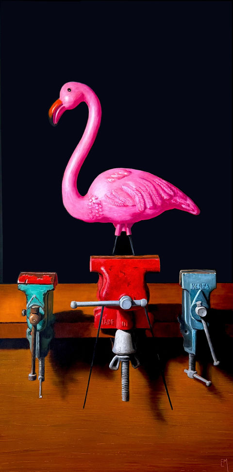 A pink plastic flamingo clamped into a vintage vise on a table.