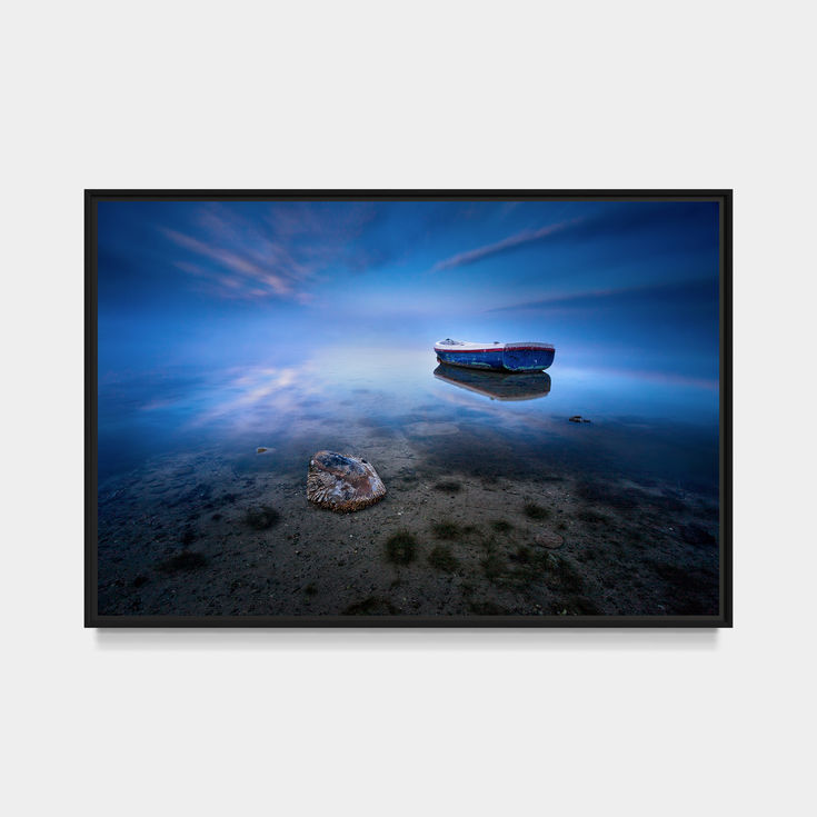 Photo de l'Étang de l'Or avec une barque solitaire et reflets.