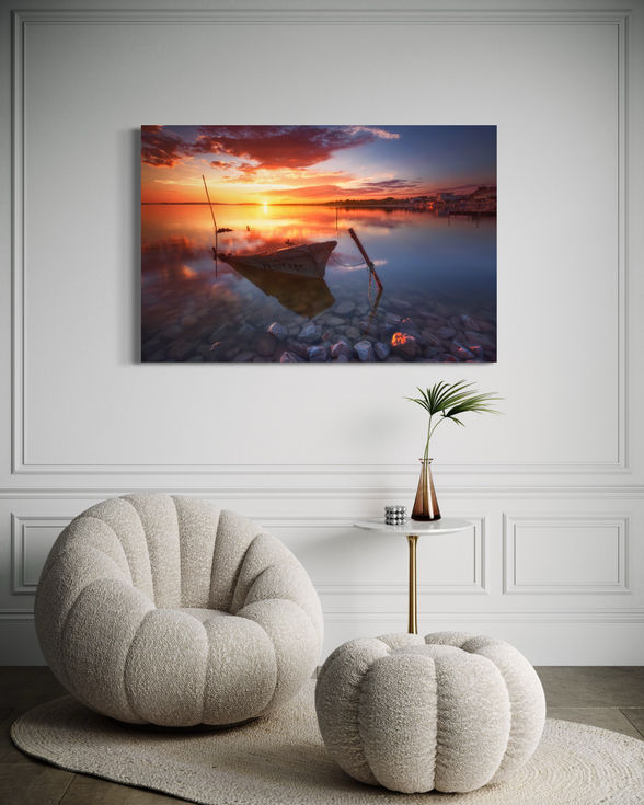 Barque et paysage de l'étang de Pérols au coucher du soleil, avec des nuances de rose et d'orange en Occitanie