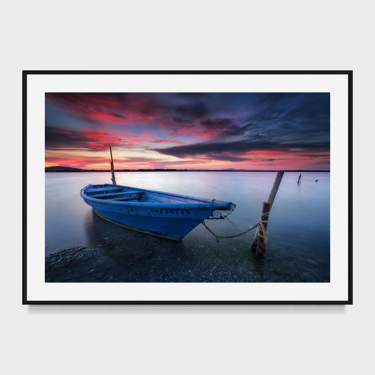 Photo d’une barque bleue au coucher de soleil sur l’étang du Méjean