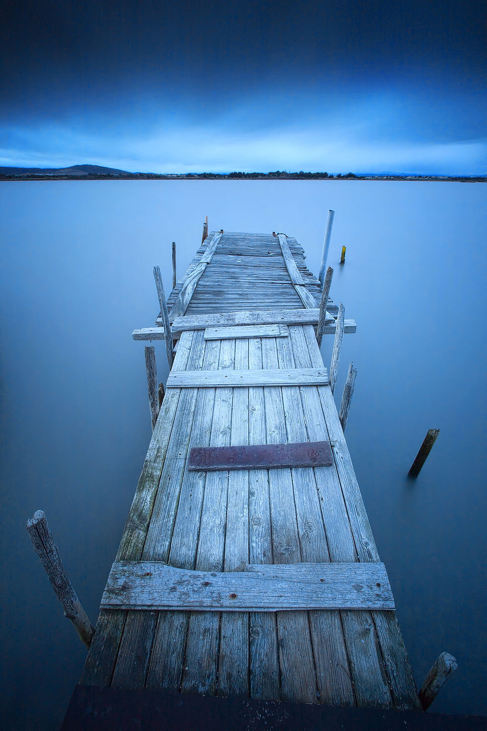 Photo d’un ponton en bois sur l’étang du Méjean à l’aube