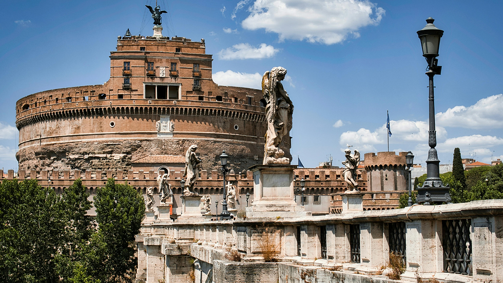 Castelo de Santo Ângelo em Roma com estátuas de mármore na ponte, céu azul com nuvens e clima ensolarado.