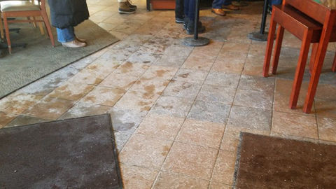 Tile lobby floor with Ice Melt tracked in creating a white layer of salt.