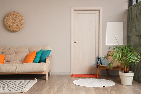 Interior of beautiful living room with comfortable sofa, armchair, pillows and houseplant.