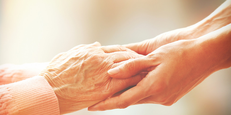 A pair of young-looking hands delecately holding the hands of an elderly person.