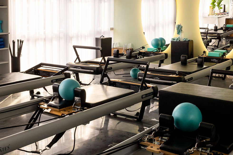 in vivo pilates reformers in the green sage studio with accessories. There are 6 reformers visible in black with straps and balls.