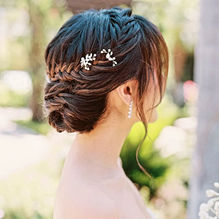 Elegant braided bridal updo with floral hairpins