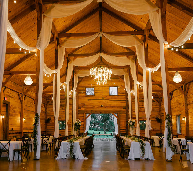 interior view of venue barn with lights and drapery