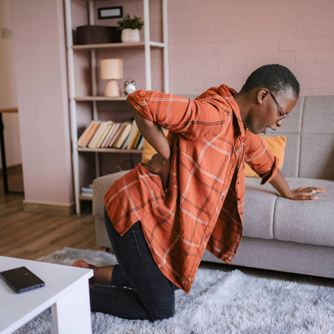 Woman kneeling with back nerve pain radiating into the legs and arms