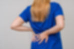 woman-holds-lower-back-in-pain-due-to-synovial-cysts-that-have-caused-spinal-stenosis
