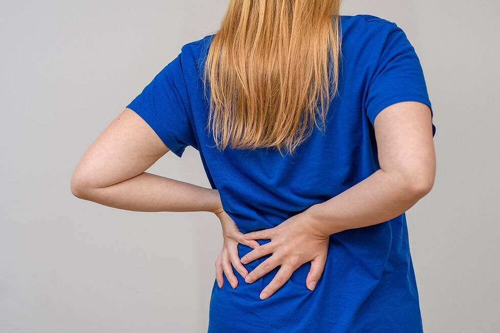woman-holds-lower-back-in-pain-due-to-synovial-cysts-that-have-caused-spinal-stenosis.jpg