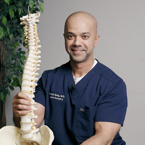 Dr. Rafath Baig holding spine model