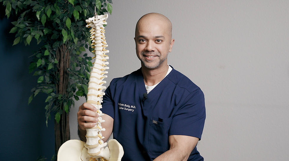 Dr. Rafath Baig holding spine model