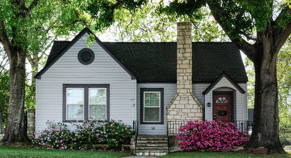 white and brown house surrounded by green trees_edited.jpg