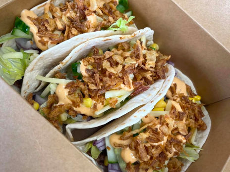 Three loaded soft tacos with fresh salad, cheese, crispy onions and sauce