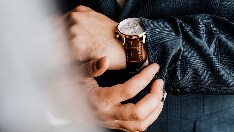 Executivo arrumando o relógio e o terno para mais um dia de trabalho