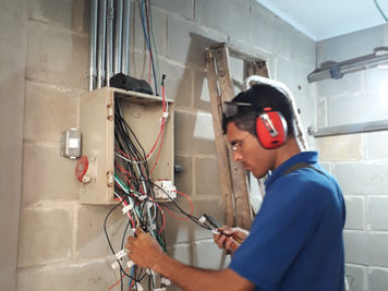 Eletricista instalando quadro de distribuição.