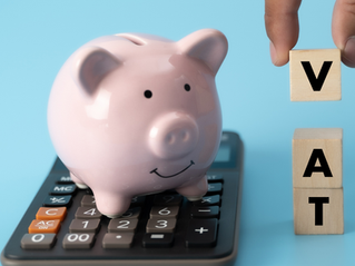 A calculator and blocks spelling VAT with a money box