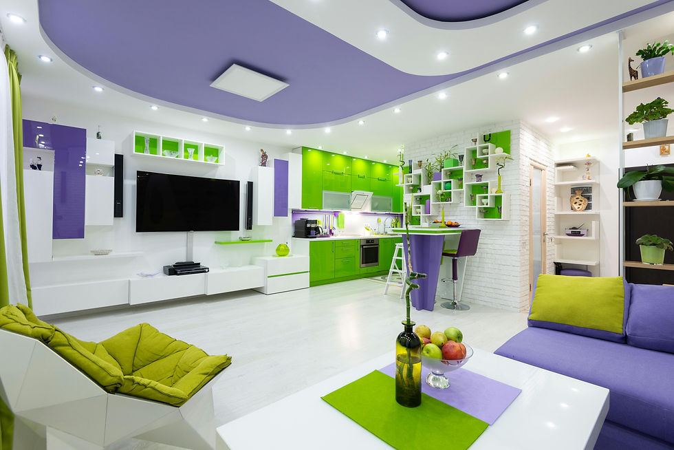 Moderne woonkamer met groene en paarse accenten. Grote tv aan de muur, heldere keuken met planten en fruit. Sfeervol en kleurrijk.