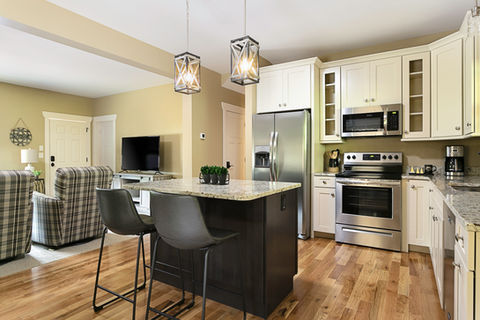 Modern kitchen with island, stainless steel appliances, and open living area.