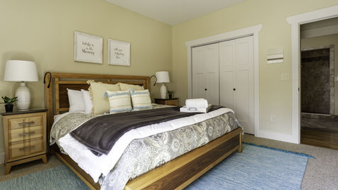 Bedroom with bed, pillows, lamps, and art on the wall, The Cedar Pictures.