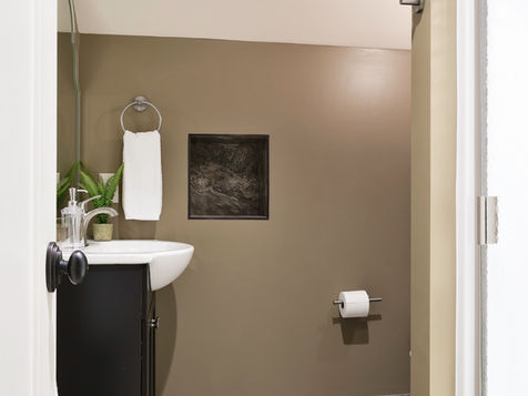 Bathroom with sink, towel, toilet paper, and shower, simple and modern design.