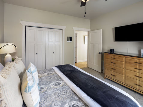 Bedroom with bed, dresser, TV and closet; Asheville Cottages New Site.