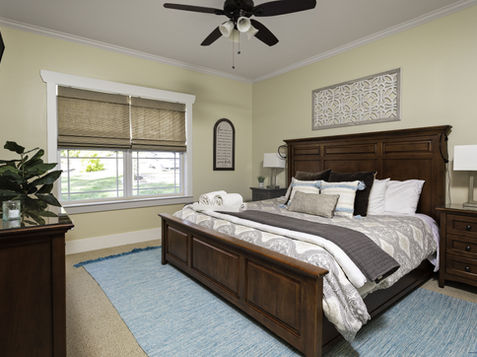 Bedroom with bed, dresser, window Asheville Cottages New Site, and other furniture.