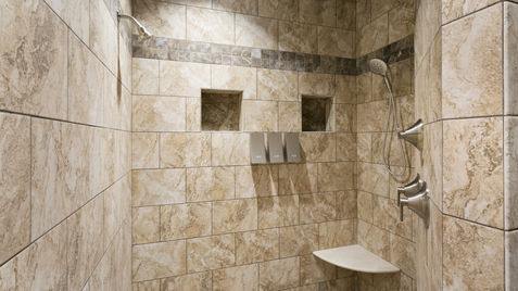 Tiled shower with built-in shelves, showerhead, and a small built-in seat.