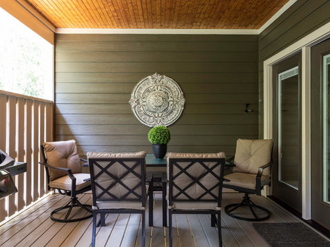Outdoor patio seating with chairs and a decorative wall hanging in situ