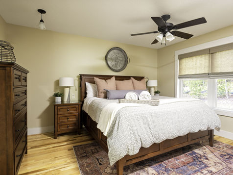 Bedroom at The Ivy Cottage with king bed, wood furniture, and large windows