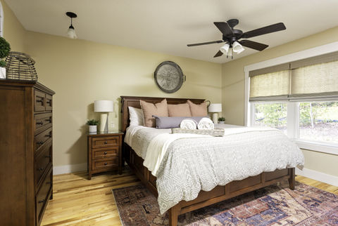 Bedroom at The Ivy Cottage with king bed, wood furniture, and large windows