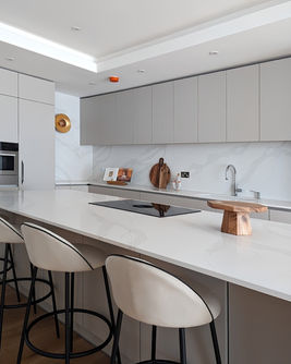 Modern London kitchen home staging with marble breakfast bar and upholstered counter stools.